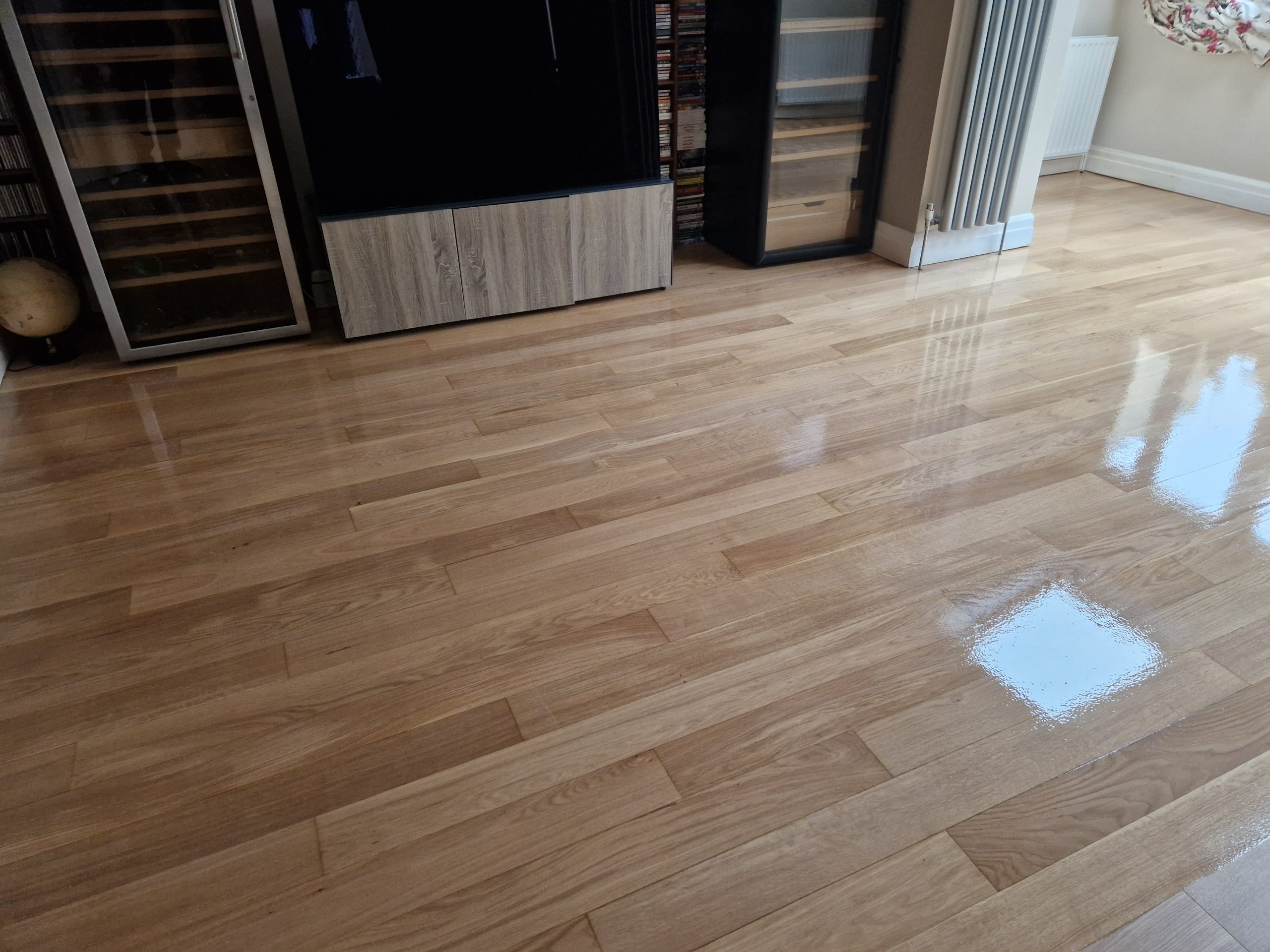 Best Time to Sand Floors – Finchley engineered oak strip wooden floor freshly sanded and sealed to a satin-gloss sheen in a living room.