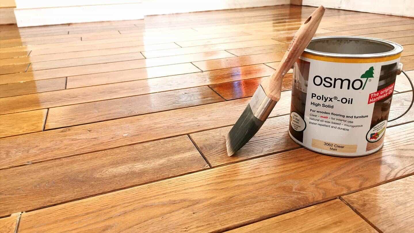 Best Time to Sand Floors – Finchley oak plank wooden floor being coated with Osmo Polyx-Oil (clear matt) using a brush after sanding for an even, durable finish.