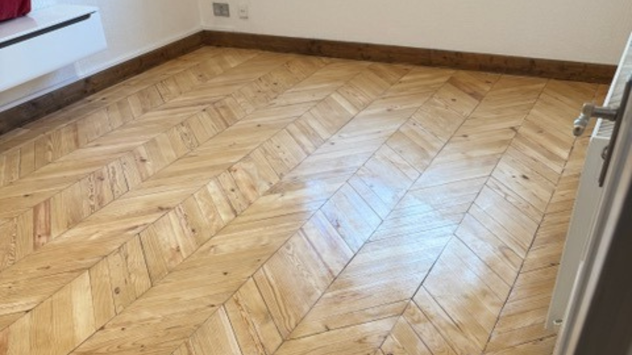 Parquet Floor Sanding in Finchley on a freshly restored oak chevron parquet bedroom floor with a smooth, glossy finish.