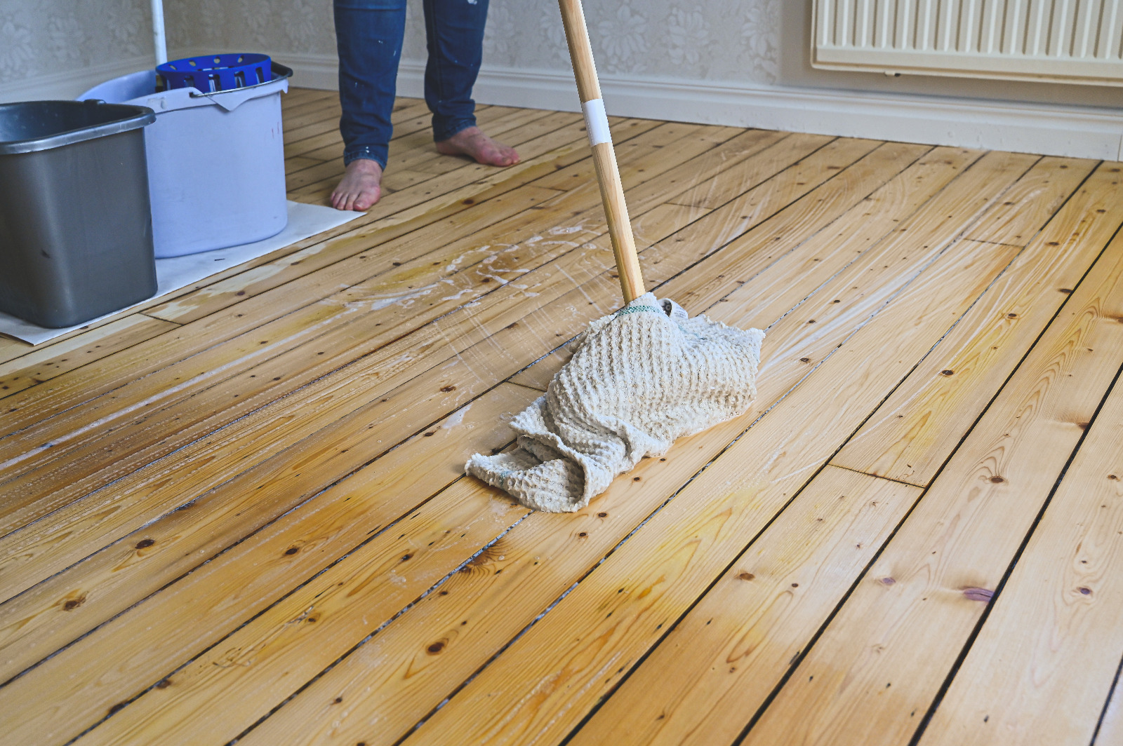 Wood Floor Sanding in Finchley – freshly sanded softwood pine floorboards being gently cleaned and mopped as part of post-sanding care.