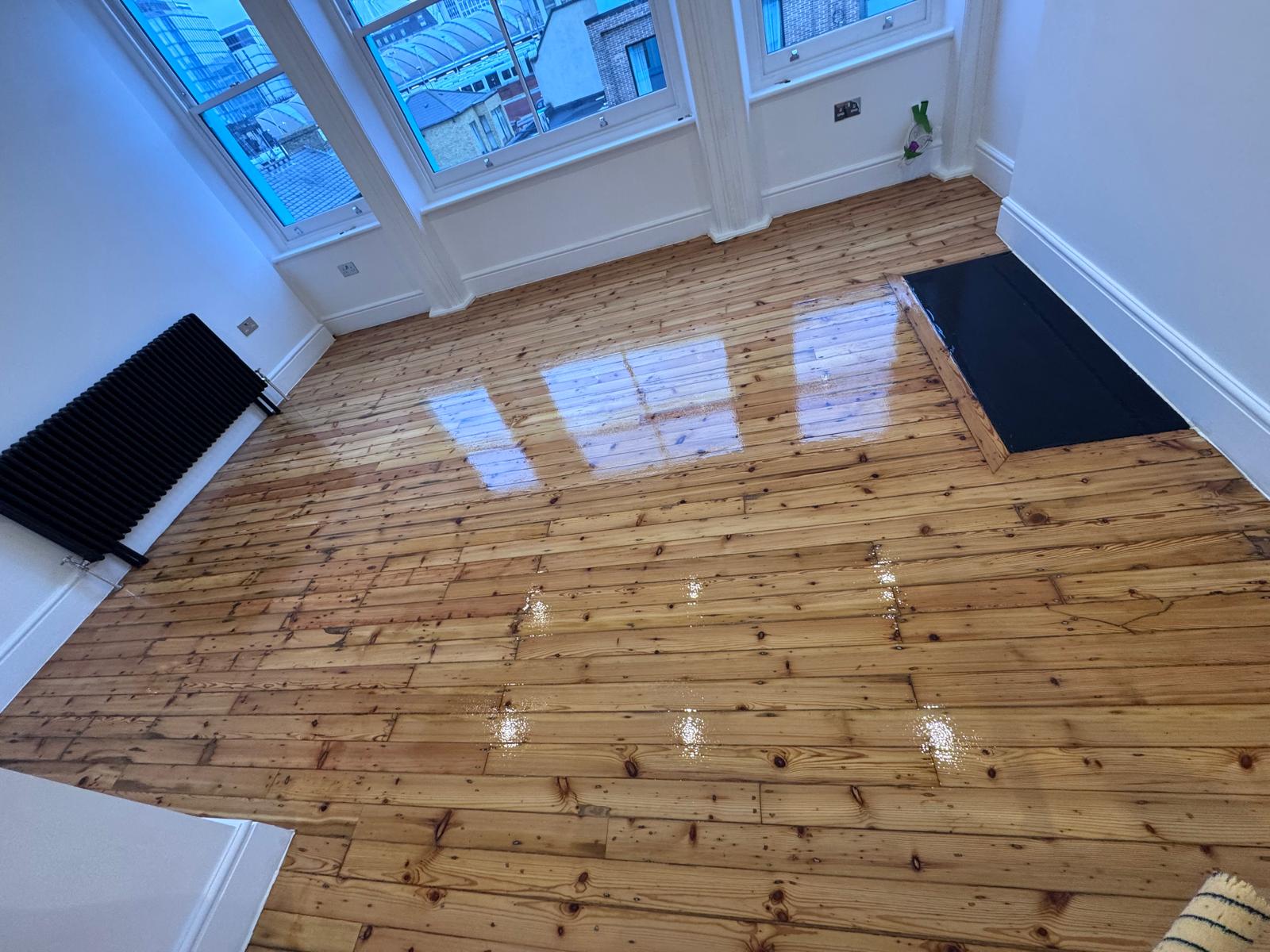 Wood Floor Sanding in Finchley – bright living room with finished softwood pine floorboards, freshly lacquered and gleaming after sanding and sealing.